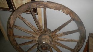 An old wooden cart wheel with metal rim.