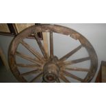 An old wooden cart wheel with metal rim.