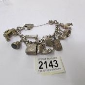 A heavy sterling silver charm bracelet with 11 charms and heart lock, hall marked Birmingham 1972.