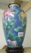 A large Cloissonne' vase with depictions of butterflies and chrysanthemums with stand.