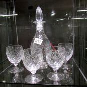 A cut glass decanter and 4 glasses.