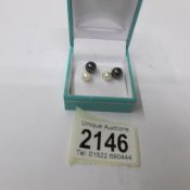 A pair of gold set cultured pearl earrings in black and white pearls.