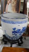 A large blue and white planter on stand (chip to rim),