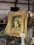 A gilt framed picture of a lady watering plants