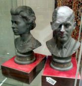 A pair of Royal Doulton busts of Queen Elizabeth II and Prince Philip on wooden bases.