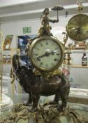 A mantel clock supported by an elephant.