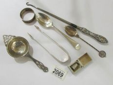 A silver handled button hook, a silver tea strainers, silver sugar nips, silver spoons etc.
