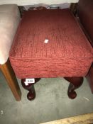 A red fabric covered foot stool with Queen Anne legs