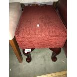 A red fabric covered foot stool with Queen Anne legs