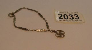 A mid 20th century 9ct gold chain with a 9ct gold swastika pendant.