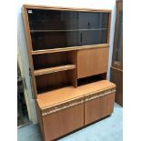 A wall unit with sliding glass and a drinks cabinet and drawers