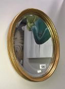 A gilt framed oval bevel edge mirror