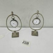 2 pocket watches on stands.