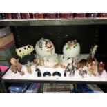 A shelf of animals ornaments including a large piggy bank and a cast iron door stop