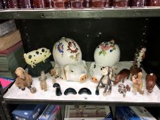 A shelf of animals ornaments including a large piggy bank and a cast iron door stop