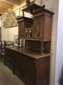 An ornate Edwardian sideboard featuring floral carvings in the Arts & Crafts style