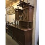 An ornate Edwardian sideboard featuring floral carvings in the Arts & Crafts style