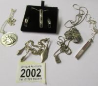 2 silver pendants with earrings sets and 3 silver pendants.