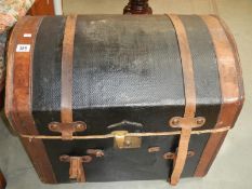 A domed leather trunk including upper compartment