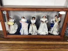 A display cabinet with 5 dolls as house maids