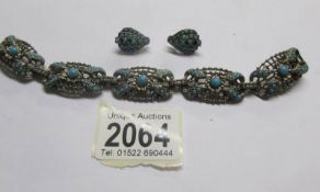 A bracelet set with turquoise stones together with a pair of clip on earrings also set with