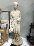 A garden statue of a lady with water jug