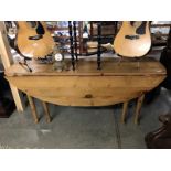 A large oval pine drop leaf table