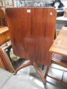 An Edwardian mahogany tip up tea table with string inlay to legs