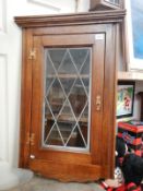 A leaded glass oak corner cupboard