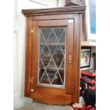 A leaded glass oak corner cupboard