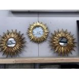 A Karlsson sunburst wall clock and a pair of matching mirrors