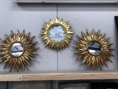 A Karlsson sunburst wall clock and a pair of matching mirrors