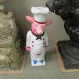 A large cast iron figure of a pig chef.