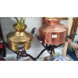 A copper and a brass planter on African folding wood stands