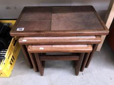 A tile topped teak nest of tables