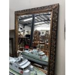 A large ornate framed bevel-edge mirror. Approximately 47.25 x 37.