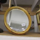 An oval gilt framed mirror.