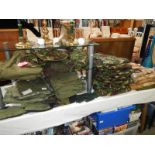 A large quantity of UK combat clothing including boiler suits, t-shirts, jackets, hats etc.