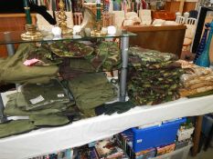 A large quantity of UK combat clothing including boiler suits, t-shirts, jackets, hats etc.