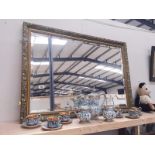 A large gilt framed bevel edged mirror