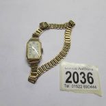 A vintage ladies rolled gold cased wrist watch with linked wrap over bracelet.