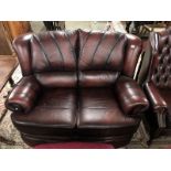 An oxblood 2 seater sofa