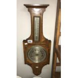 A wall barometer with thermometer