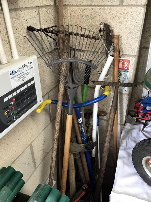 A quantity of garden tools including rakes etc.