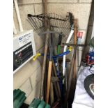 A quantity of garden tools including rakes etc.