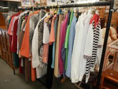 A rail of vintage and modern clothing including shirts, coats, dresses, jackets etc.