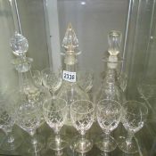 3 cut glass decanters and a quantity of glasses.