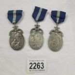 2 silver medals and one other, all with dedications on backs.