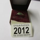 A 3 stone emerald with 2 diamonds yellow gold ring.