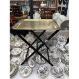 An engraved brass butlers tray on folding stool